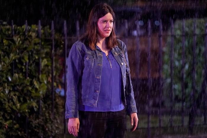 Zoe Slater standing in Albert Square looking shocked with a denim jacket on.