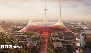 An artist's impression shows plans for a future Old Trafford stadium. It is a dome-shaped stadium with three spires from which netting descends and is stretched out to mooring points around the stadium. A large number of apartment blocks line the main route up to the stadium. They are about five storeys high, and have solar panels and grass on their roofs.