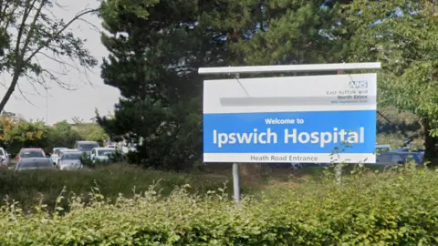 Google Maps The blue and white Ipswich Hospital sign against a backdrop of greenery, including trees and bushes