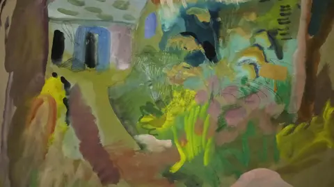 Robjn Cantus A painting of a garden scene in vivid colours including shades of green, yellow, pink, cream and brown. It is in a loose impressionistic style and shows a path on the right leading to a blue doorway, while on the left if a blowsy flower bed.