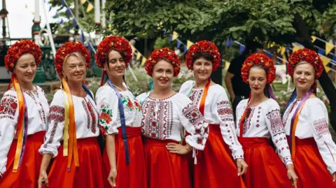 Anastasiia Moskalenko Ukrainian women dressed in red skirts and white decorated tops at last year's UkraineFest. They are also wearing red head dresses.
