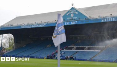 A corner flag bearing the Sheffield Wednesday badge sits in front of the south stand at Hillsborough