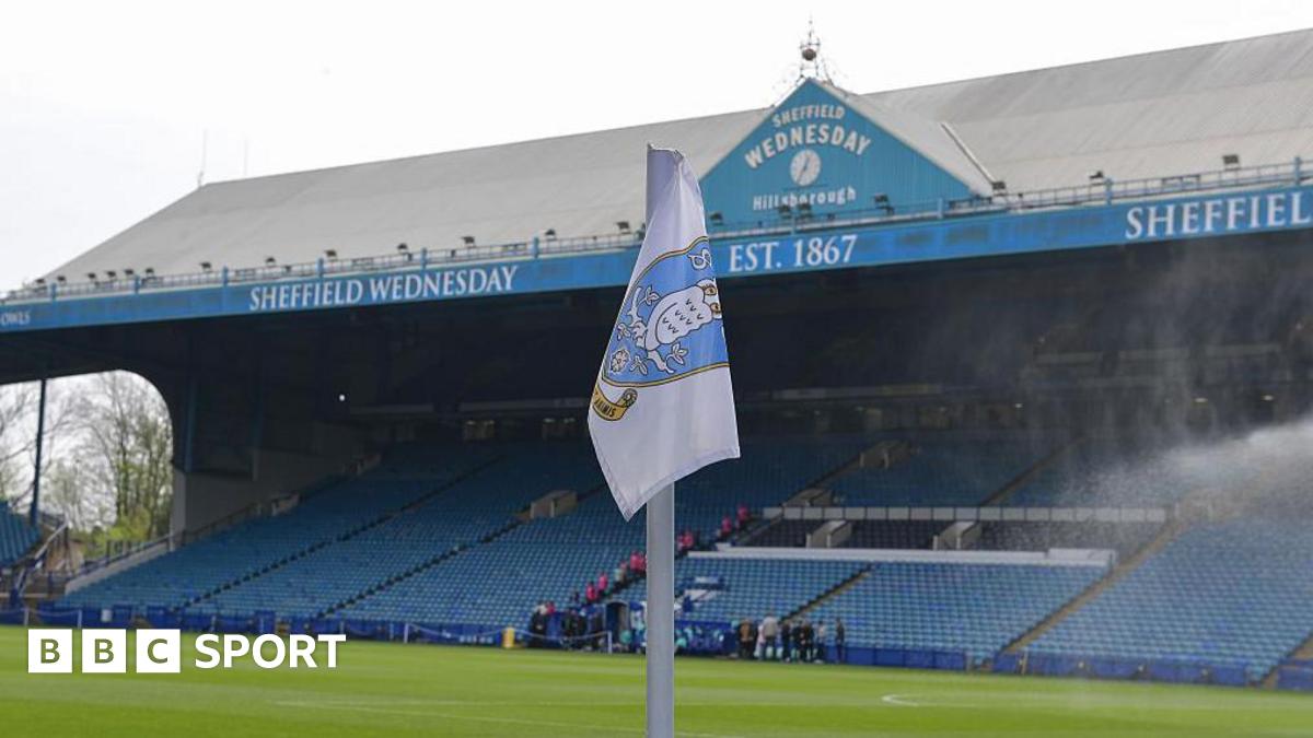 A corner flag bearing the Sheffield Wednesday badge sits in front of the south stand at Hillsborough