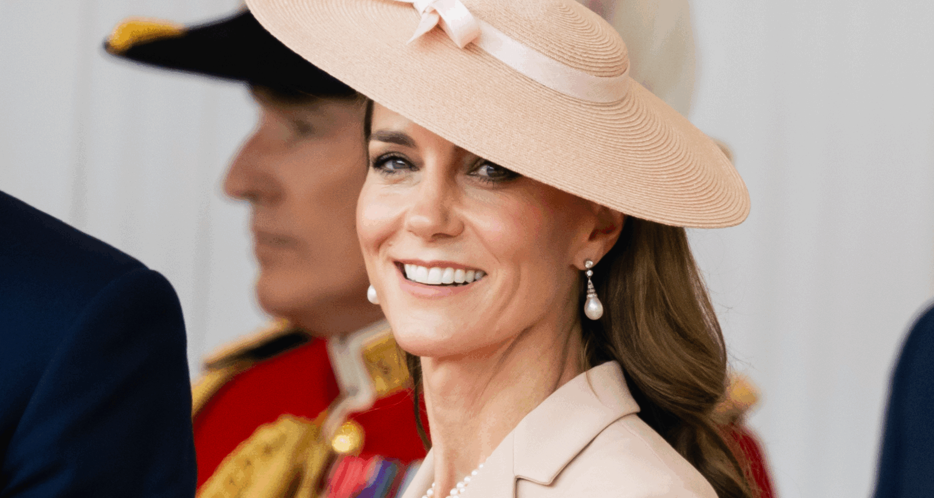 Princess Kate wearing a pink hat with a bow smiling