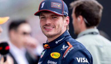 Max Verstappen smiling at the camera in Red Bull F1 team kit