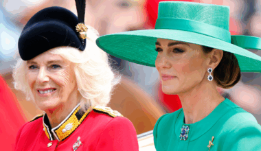 Queen Camilla wears a red uniform while Kate Middleton wears a green dress and matching hat