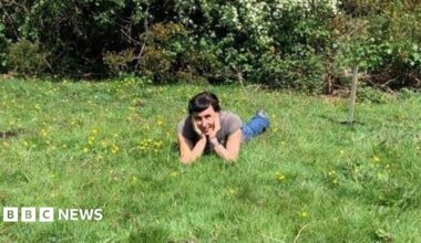 Sonia Rosenblatt lying on the grass at the nature reserve next to the trees that were planted