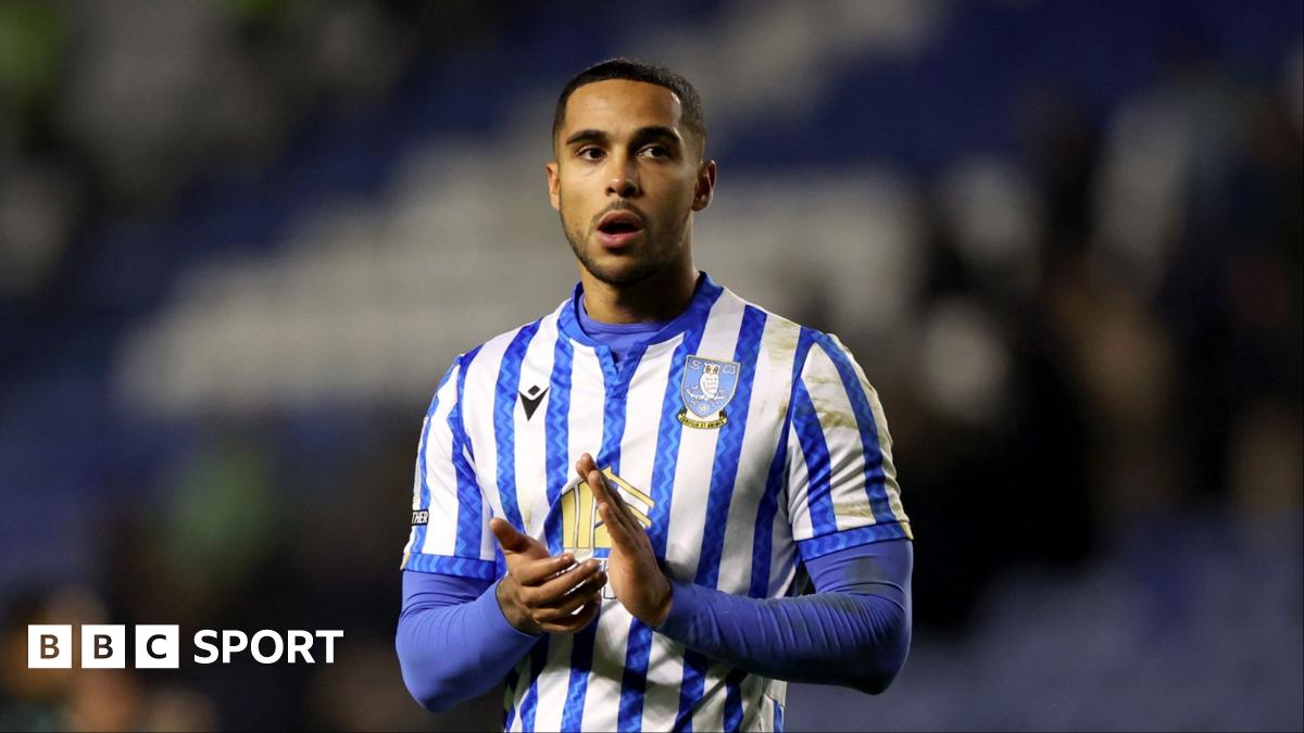 Defender Max Lowe wearing a blue and white striped Sheffield Wednesday shirt claps with a disappointed look on his face
