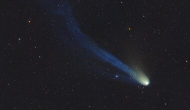 a bright dot leaves a hazy trail behind it as it flies in front of background stars