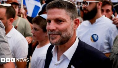 A close up shot of  Israeli Finance Minister Bezalel Smotrich during an event at the Damascus Gate in Jerusalem's Old City. He is surrounded by police officers and young supporters.