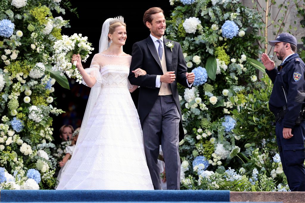 Princess Marie Caroline of Liechtenstein and Mr. Leopoldo Maduro Vollmer leaving their wedding, posing in front of a giant arch of flowers