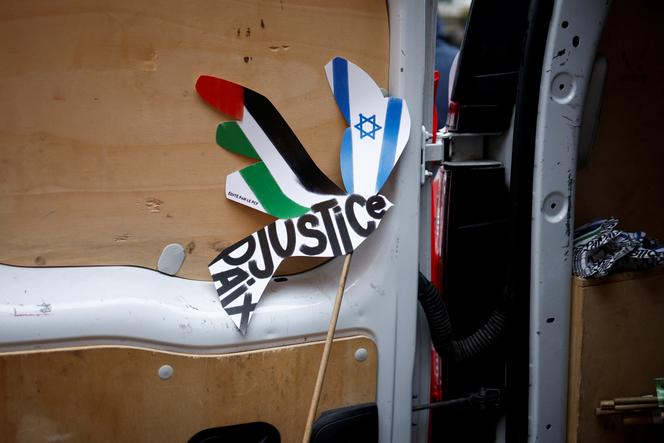 A placard with Palestinian and Israeli flags reading 