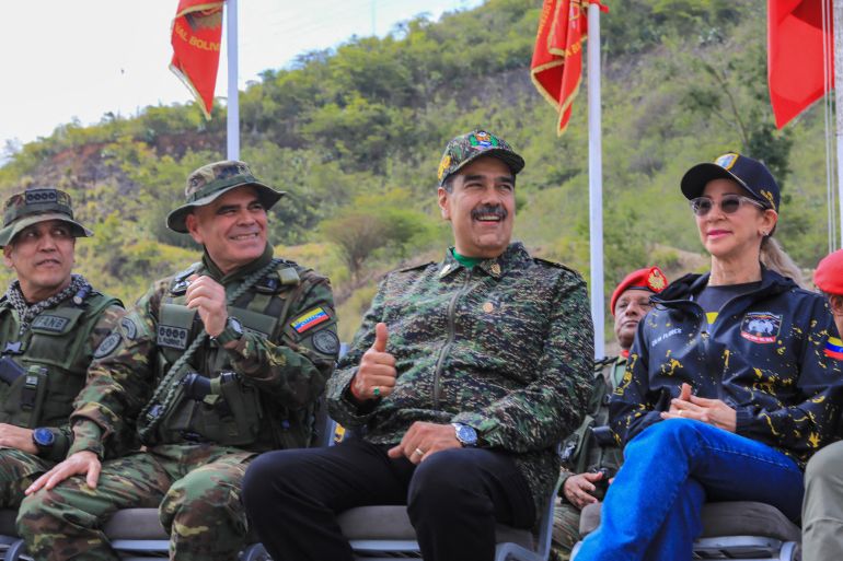 This handout picture released by the Venezuelan Presidency on August 28, 2025, shows Venezuela's President Nicolas Maduro (C-R) giving a thumbs up next to Defense Minister Vladimir Padrino Lopez (C-L) and First Lady Cilia Flores (R) as they watch military exercises at a training camp in Caracas. Venezuela's President Nicolas Maduro said that "there is no way" a foreign force could invade Venezuela on August 28, 2025, amid military operations announced by the United States in the Caribbean, which the leftist leader describes as a "threat" to his country. (Photo by ZURIMAR CAMPOS / Venezuelan Presidency / AFP) / RESTRICTED TO EDITORIAL USE - MANDATORY CREDIT "AFP PHOTO / VENEZUELAN PRESIDENCY / ZURIMAR CAMPOS" - HANDOUT - NO MARKETING NO ADVERTISING CAMPAIGNS - DISTRIBUTED AS A SERVICE TO CLIENTS - AFP CANNOT INDEPENDENTLY VERIFY THE AUTHENTICITY OR LOCATION, DATE, AND CONTENT OF THESE IMAGES. /