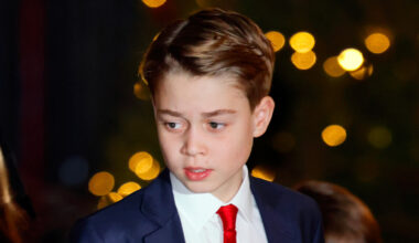 Prince George wearing a navy suit, white shirt, red tie