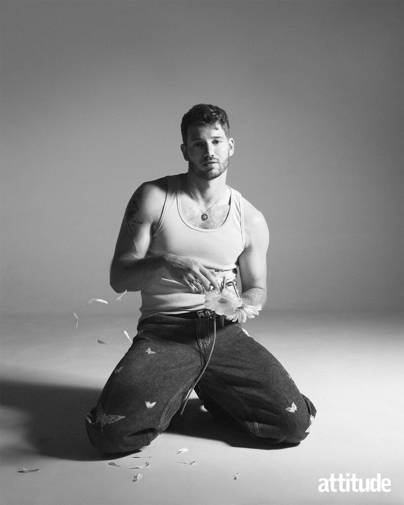 Alexander kneeling down in a vest and jeans, black and white shot