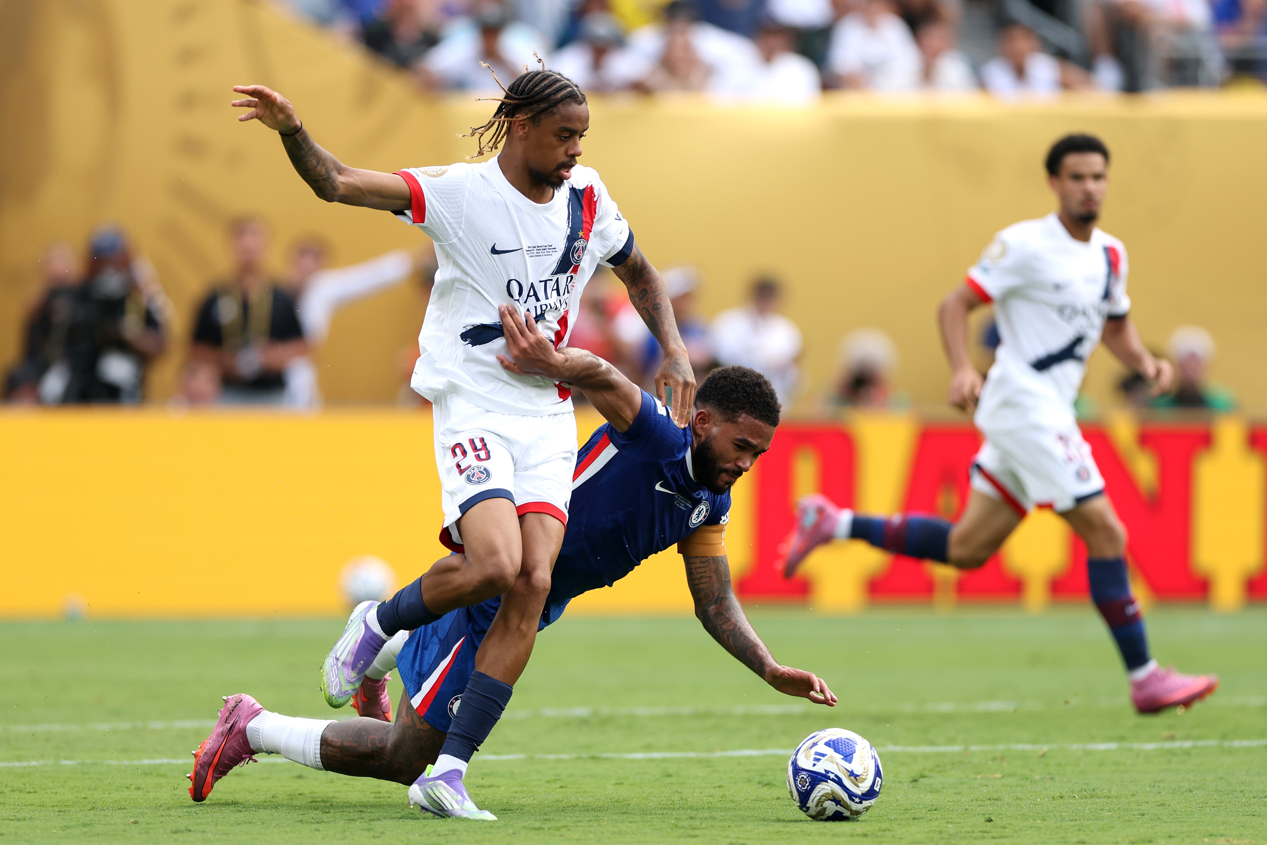 Reece James falls to the floor as Bradley Barcola dribbles past with the ball.