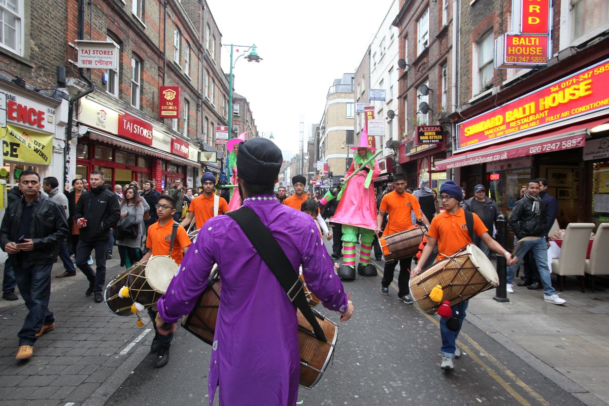 A colourful procession taking place on Brick Lane