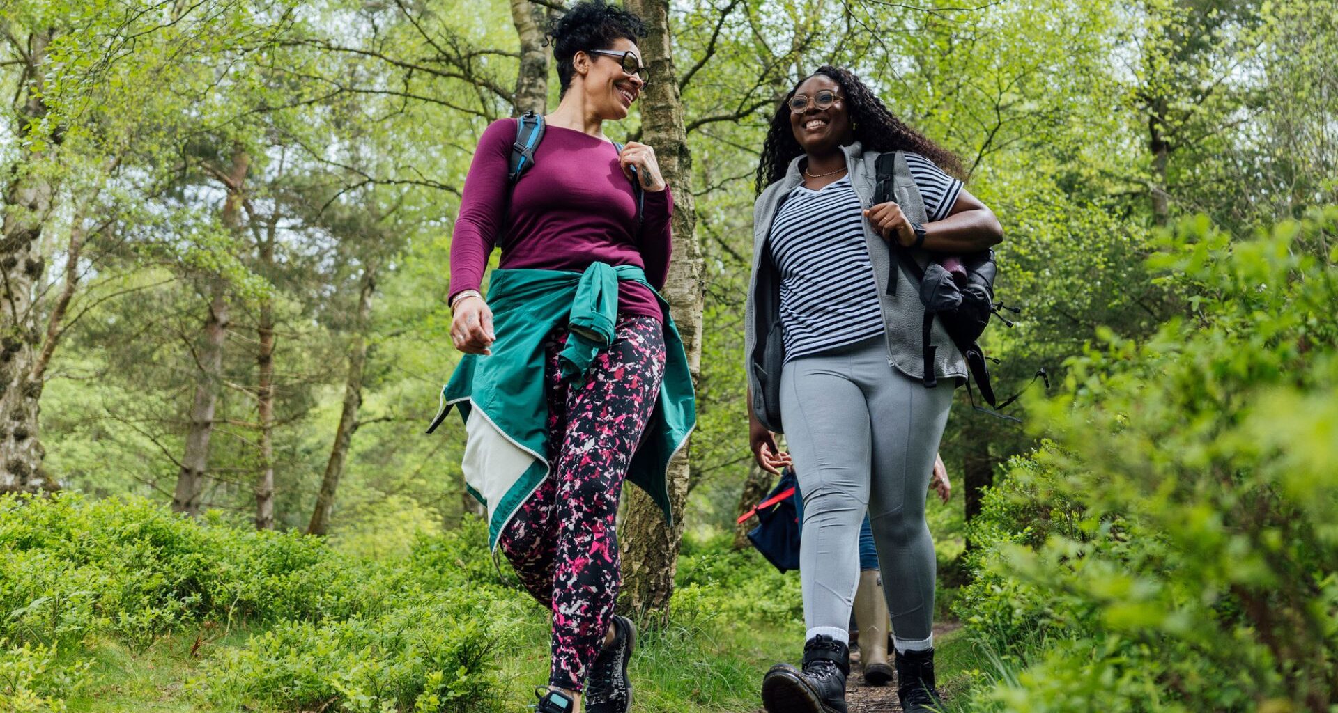 woman walking through a wooded area on a hike