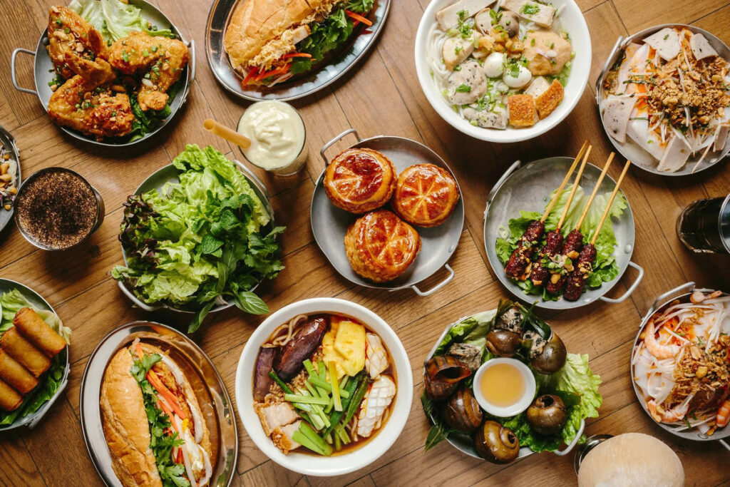 an array of vietnamese dishes presented on a wooden table
