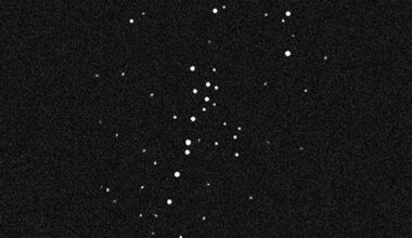 black and white image of deep space showing several dozen stars, which appear as white dots of varying sizes
