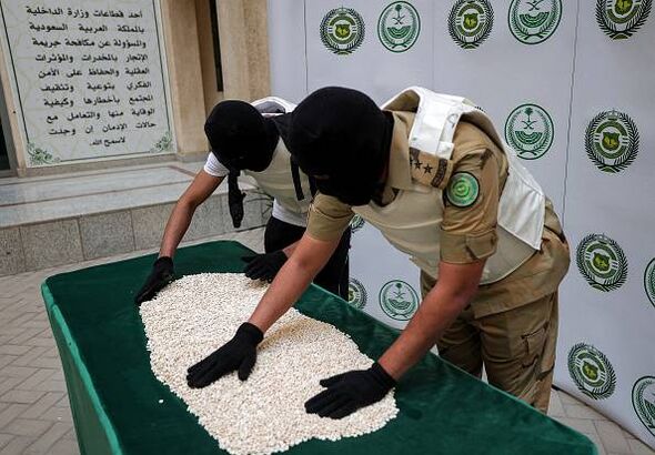 Officers of the Directorate of Narcotics Control of Saudi Arabia's Interior Ministry sort through tablets of captagon.