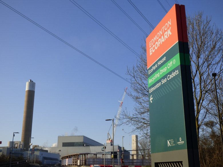 Sign at incinerator site says Edmonton EcoPark. View of existing facility and construction site in background.