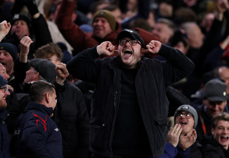 Football fans taunt rivals supporters during a game