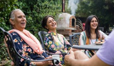 Pakistani multi generation family sitting around a table in a garden in Middlesbourgh, North East of England.