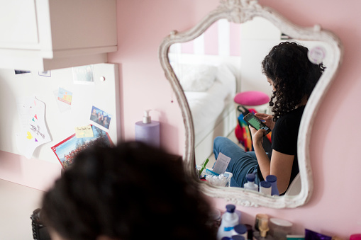 Over the shoulder view of a teenage girl using her smart phone