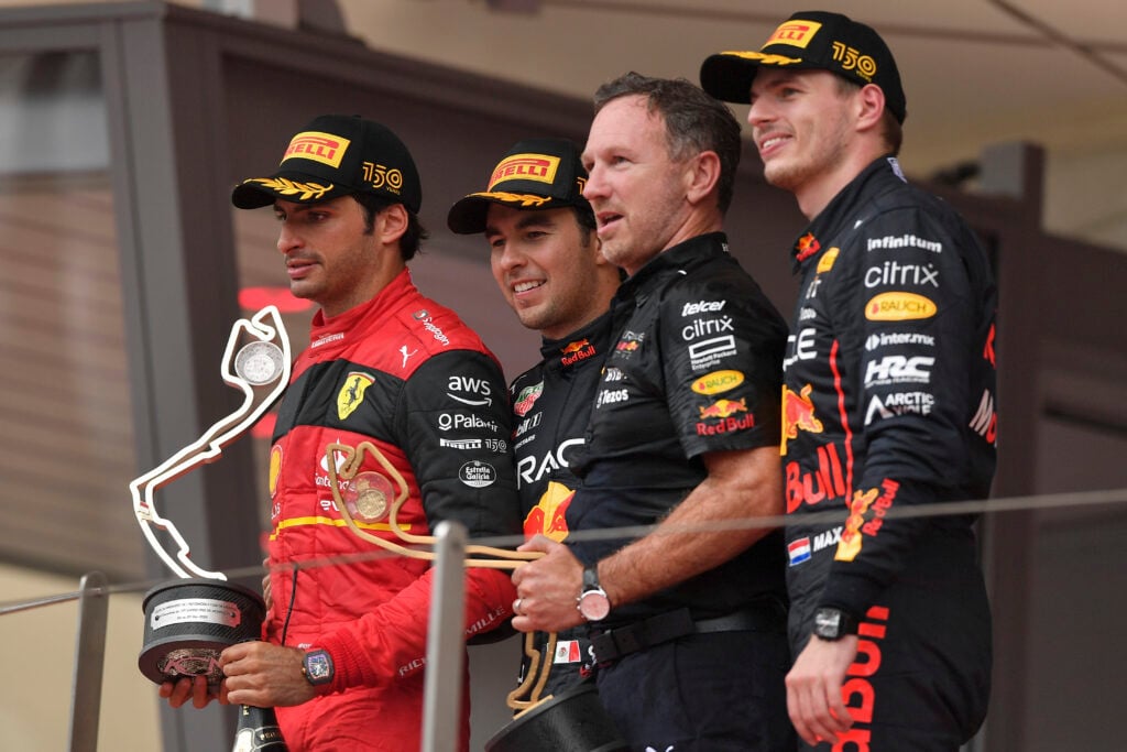 Ferrari driver Carlos Sainz on the podium at the Monaco Grand Prix with Red Bull drivers Sergio Perez and Max Verstappen, and Red Bull team principal Christian Horner
