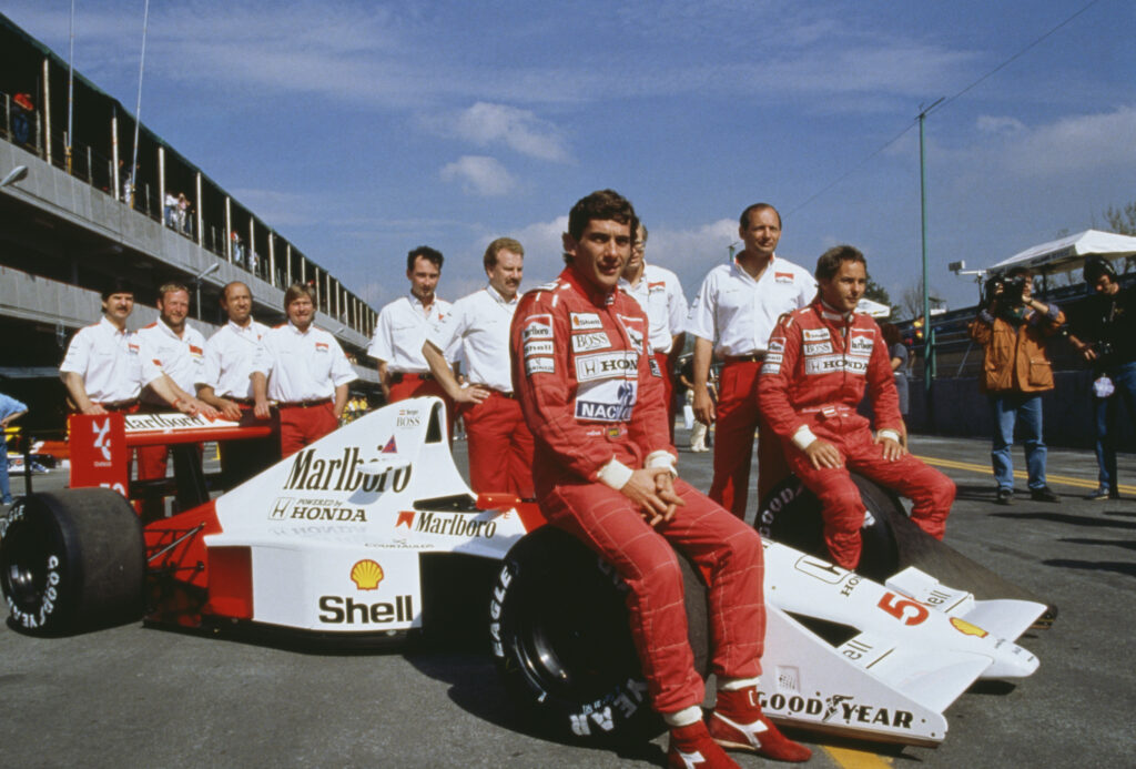 Ayrton Senna ( centre) and his teammate Gerhard Berger (right) pose with the rest of the McLaren team