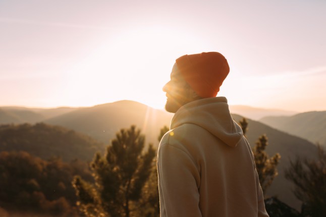Young man practicing meditation in nature at sunrise