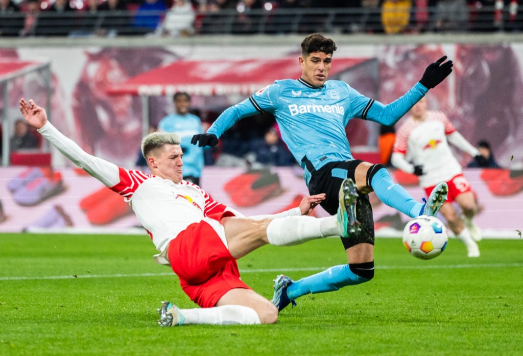 Piero Hincapie blocks a shot from Benjamin Sesko during a game between RB Leipzig and Bayer Leverkusen in the Bundesliga