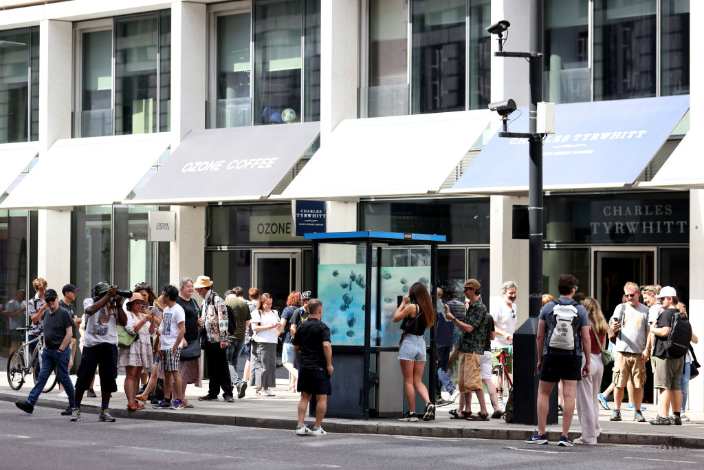 LONDON, ENGLAND - AUGUST 11: A general view as members of the public photograph and take selfies with an Artwork featuring a school of fish by Banksy, adorns a City of London Police Box on Ludgate Hill on August 11, 2024 in London, England. The elusive street artist posted a picture of the artwork earlier today on his Instagram account, his usual method of claiming credit. It came after he debuted six other works in London in as many days. It was the seventh new animal-themed artwork debuted in London this week by the elusive street artist. (Photo by Ryan Hiscott/Getty Images)