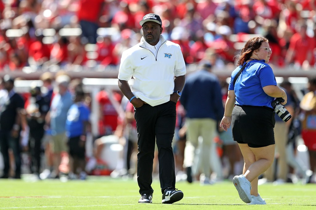 Middle Tennessee coach and photographer on the field.