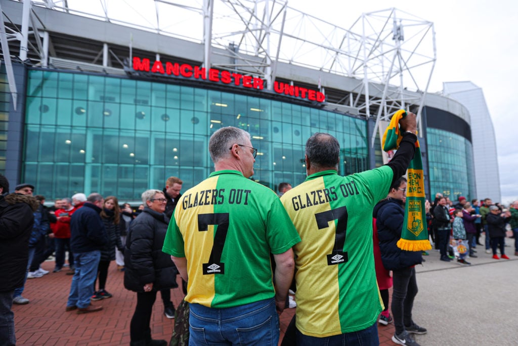 Two Manchester United fans wearing 'Glazers out' shirts outside Old Trafford on a matchday