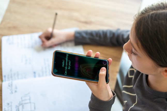 Young girl uses AI virtual assistant to do schoolwork