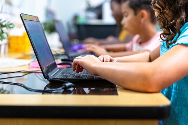 Elementary Students learning in the computer lab with their teacher