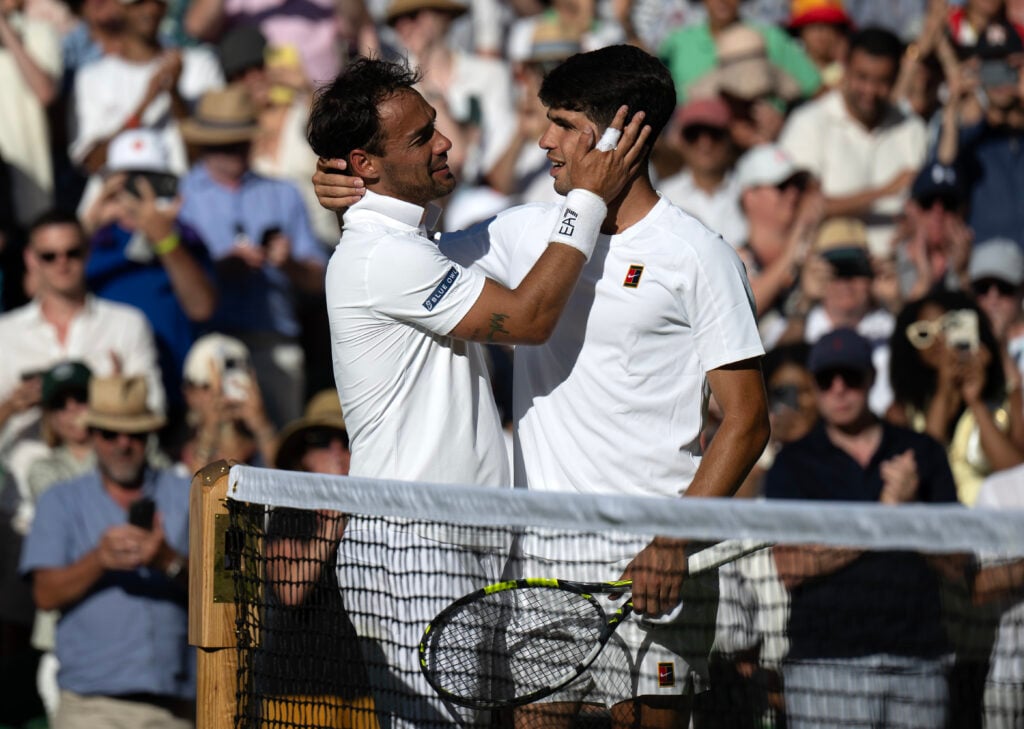 Fabio Fognini and Carlos Alcaraz embrace at the net after their first-round match at Wimbledon in 2025