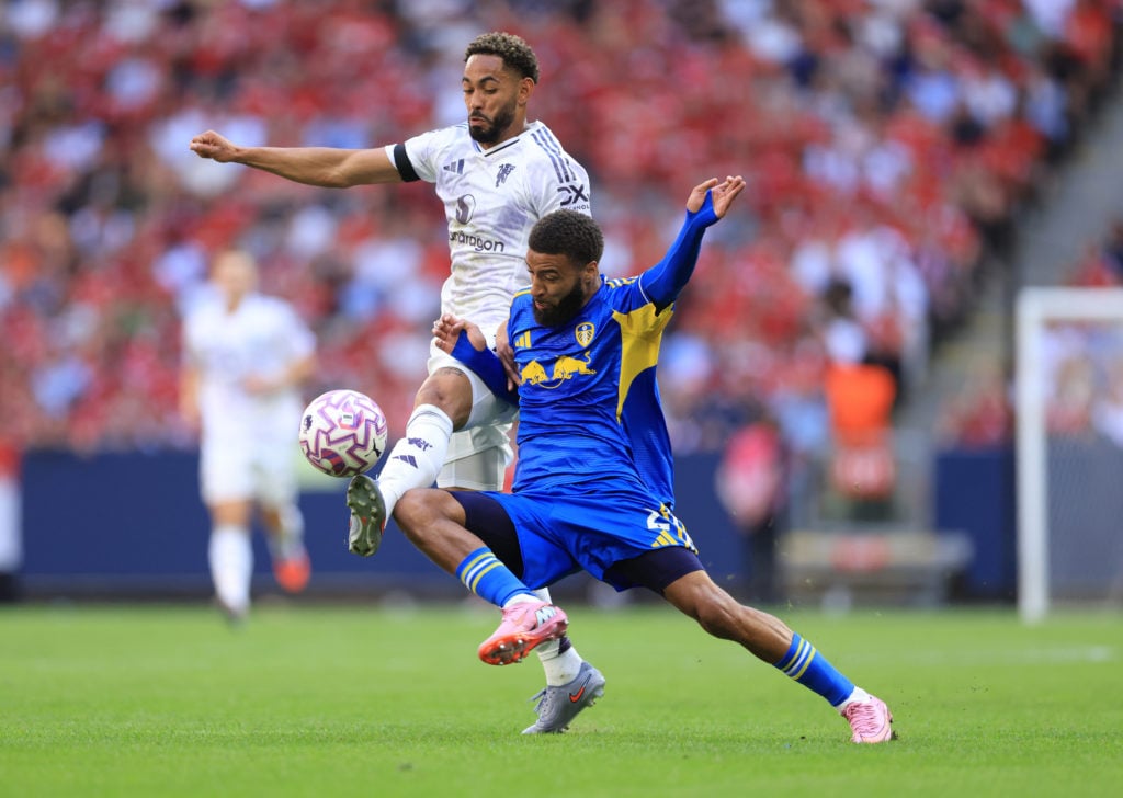 Matheus Cunha tussles with Jayden Bogle for the ball.