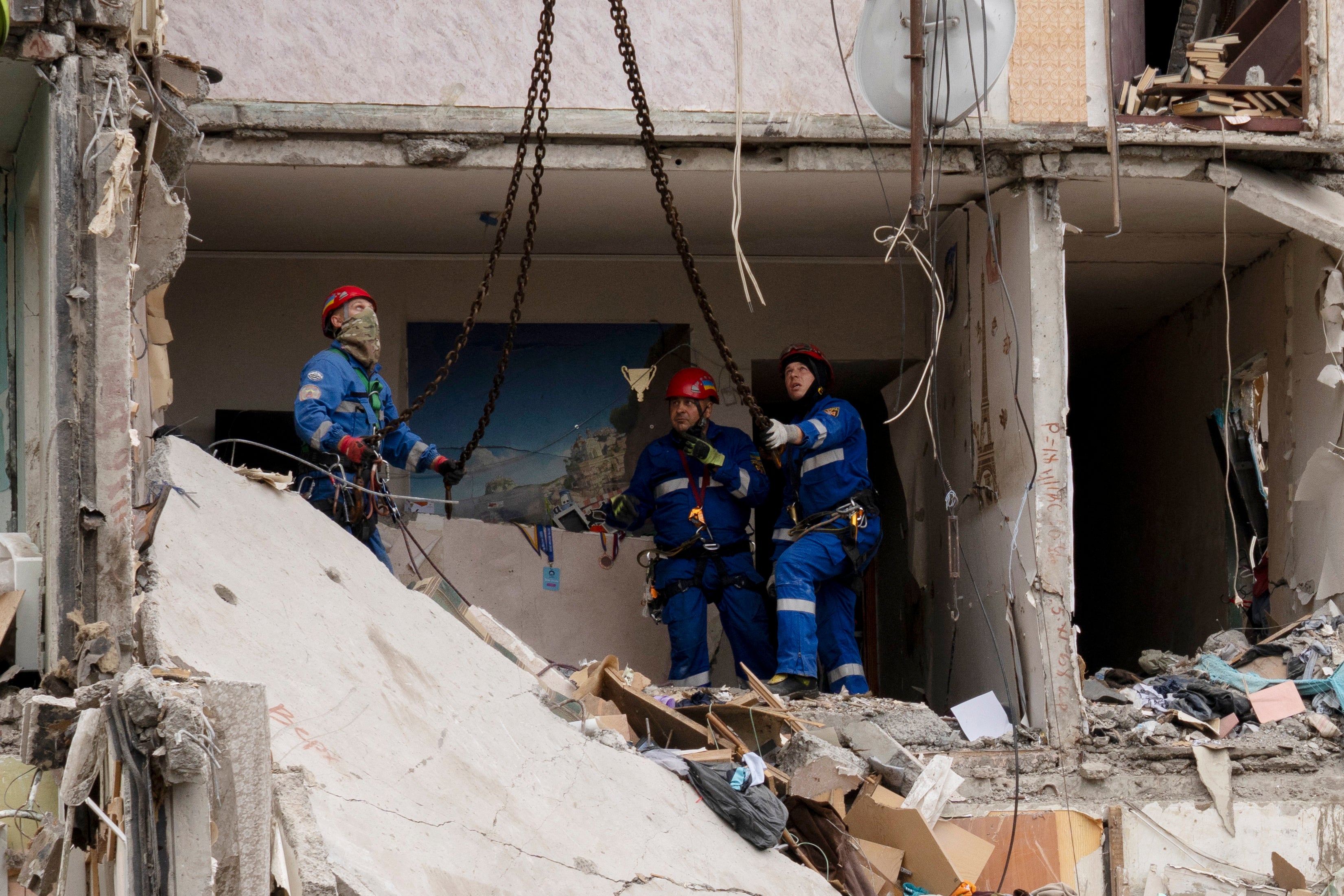 Ukrainian rescuers work among the rubble inside of a destroyed residential building at the site of an air attack in Kyiv on July 31, 2025