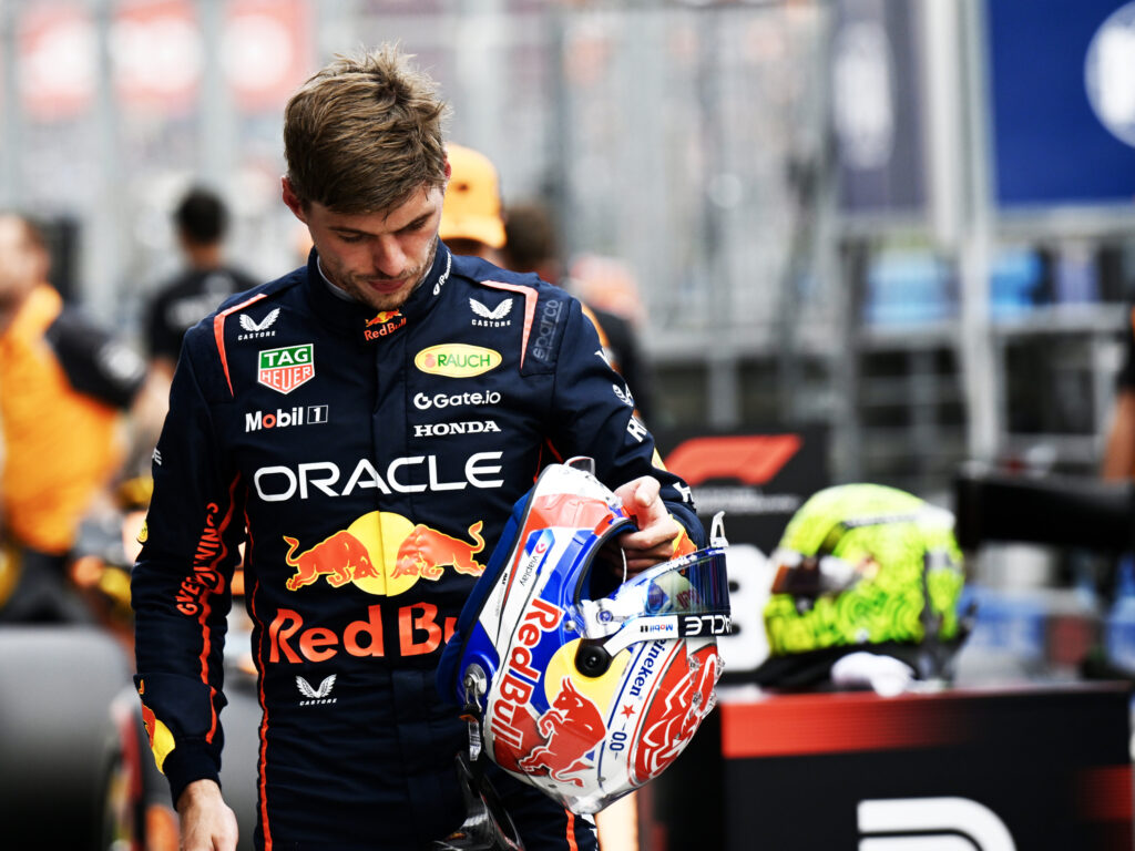Max Verstappen of Red Bull Racing walks with his helmet in his hand.