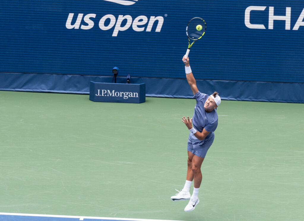 Holger Rune of Denmark serves during 1st round of the US Open mixed doubles tournament