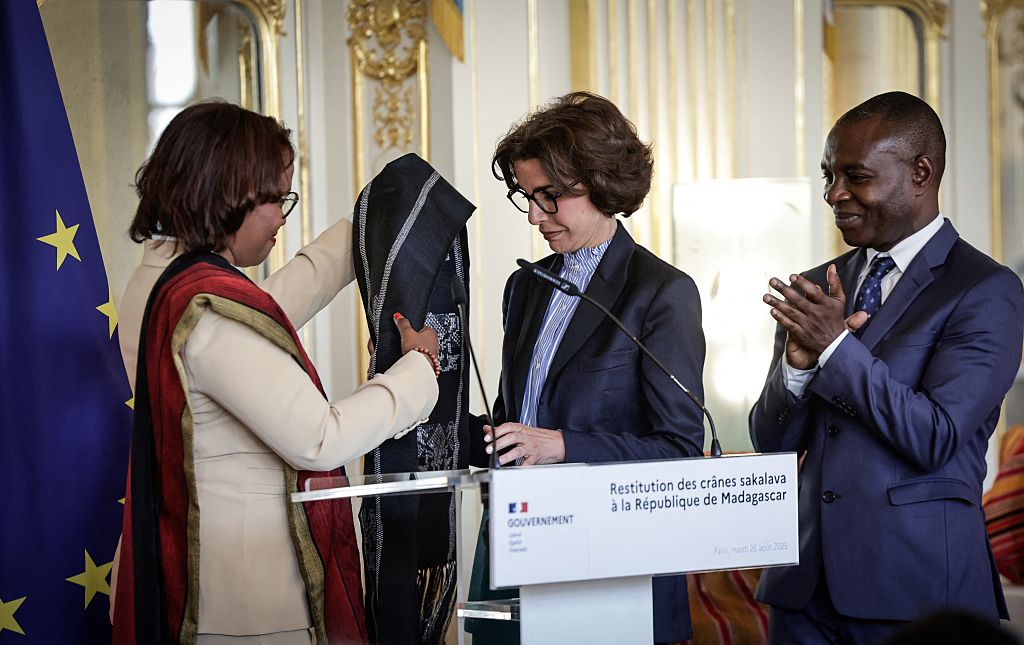 Madagascar's Minister of Culture Volamiranty Donna Mara (L) offers a gift to her France's contrepart Rachida Dati flanked by France's Delegate Minister for Francophonie and International Partnerships Thani Mohamed Soilihi during a ceremony for the restitution of three Sakalava skulls to Madagascar, at the Culture Ministry in Paris, on August 26, 2025. France returns three human skulls to Madagascar dating from the colonial era, including one attributed to the Sakalava king Toera who was beheaded by French troops in 1897, in application of a law on the restitution of human remains. (Photo by STEPHANE DE SAKUTIN / AFP) (Photo by STEPHANE DE SAKUTIN/AFP via Getty Images)