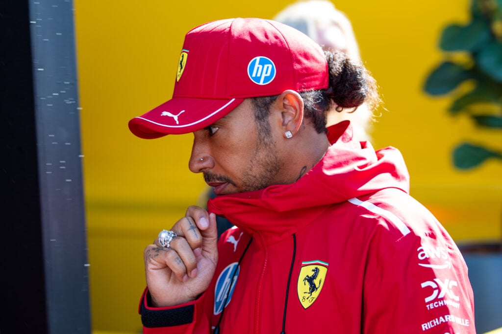 Lewis Hamilton of Ferrari walks in the F1 paddock