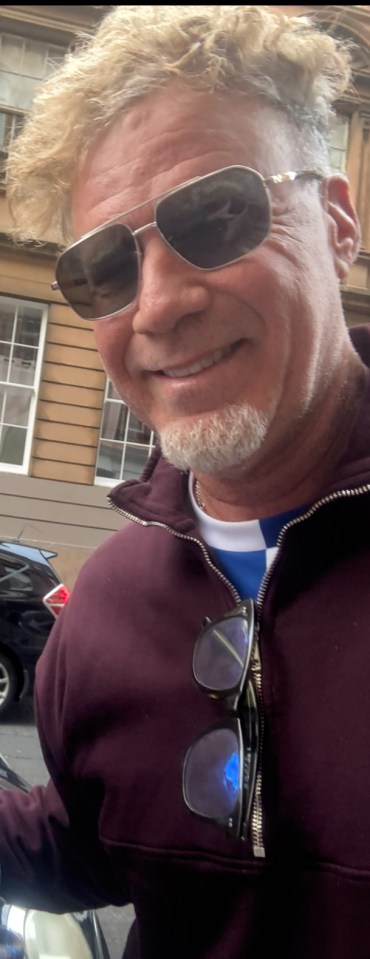 Close-up photo of a smiling man wearing sunglasses.