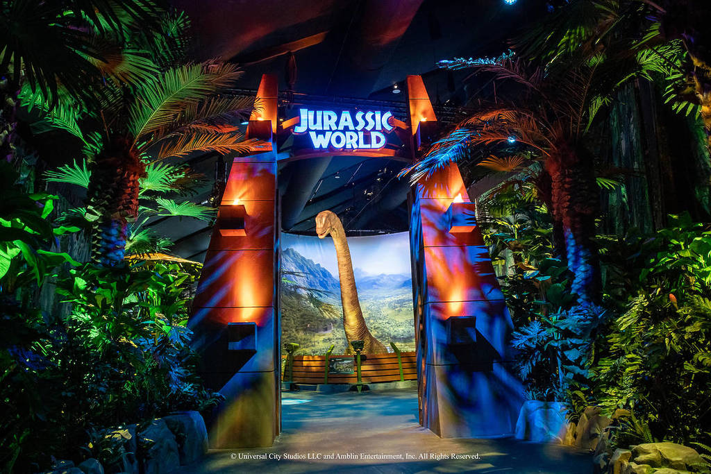 a dinosaur peeping through the Jurassic World gates