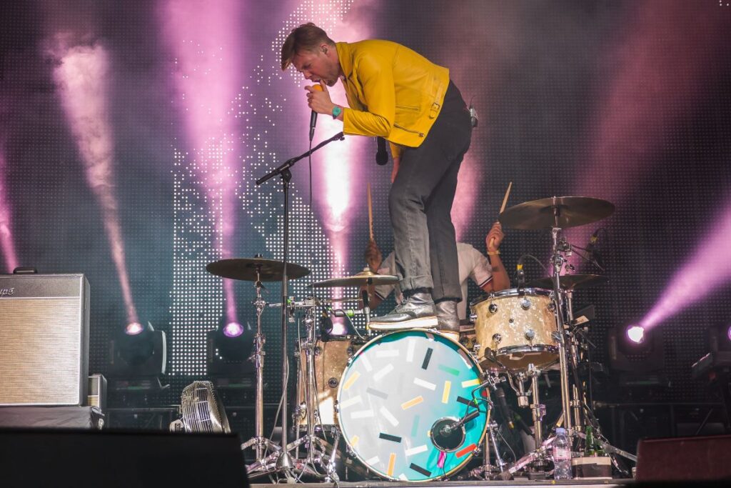 Kaiser Chiefs frontman Ricky Wilson standing on a drum