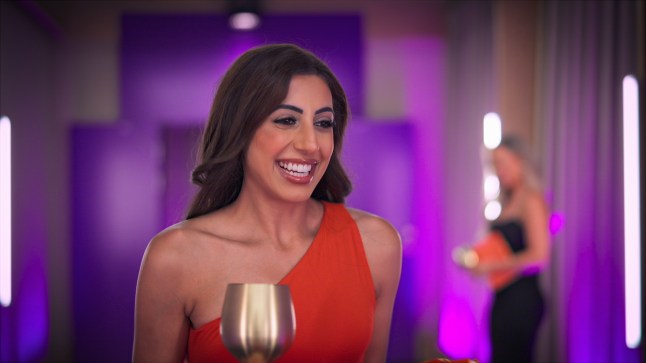 Sarover smiles while holding wine glass