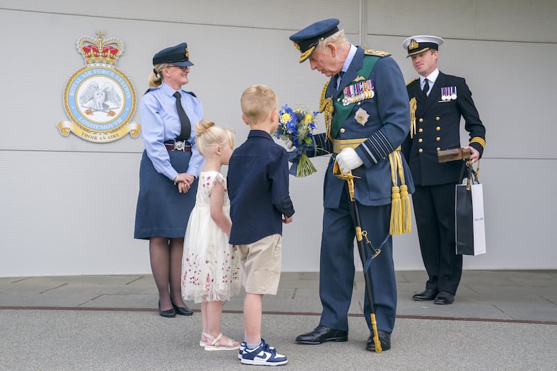 Charles is presented with flowers during his visit to RAF Lossiemouth